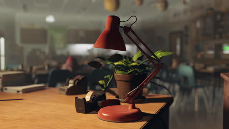 lámpara de escritorio roja en la mesa con planta