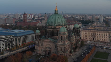 Orbit-shot-around-monumental-church-of-Berlin-cathedral-with-large-dome-at-dusk.-City-in-background.-Berlin,-Germany