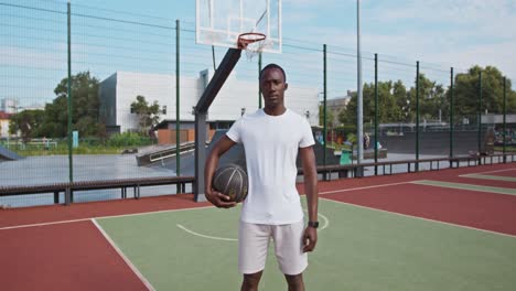 man holding basketball at outdoor court