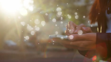 mujer caucásica sosteniendo un teléfono inteligente en strett en un día soleado con la animación de burbujas de luz aparece lentamente
