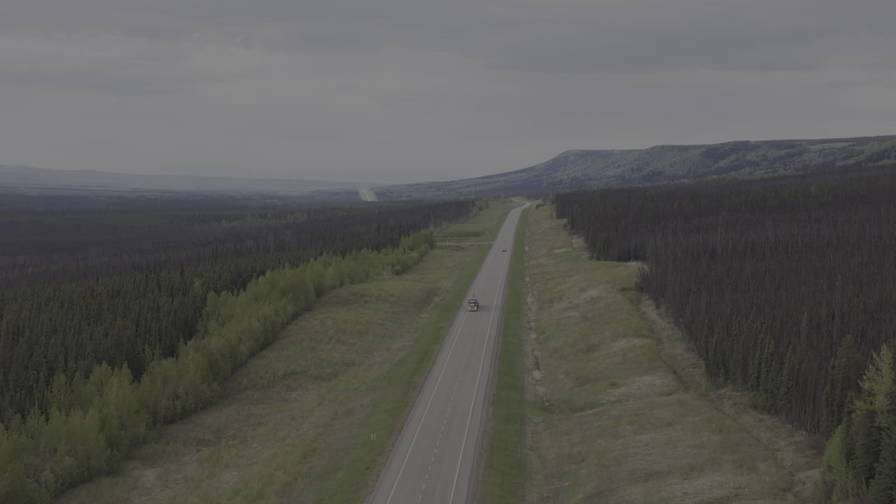 Truck cruising through the beautiful wilderness of Alaska Highway.