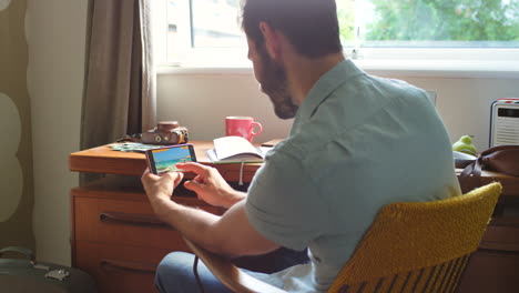 man using a smartphone for a video call at home