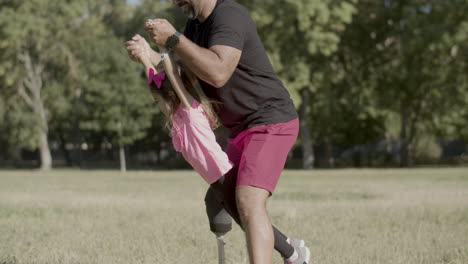 Padre-Con-Discapacidad-Sosteniendo-La-Mano-De-Su-Hija-Y-Balanceándola