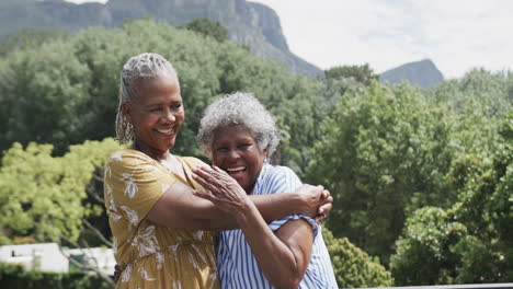 Retrato-De-Felices-Amigas-Afroamericanas-Mayores-Abrazándose-En-El-Balcón,-Cámara-Lenta