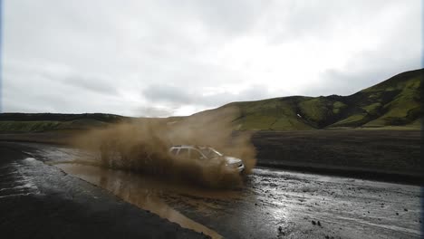 cámara lenta de un 4x4 conduciendo en un agujero de barro en islandia