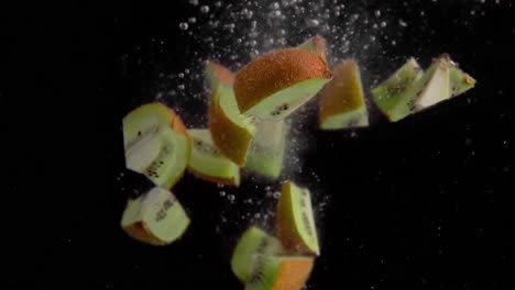 kiwi pieces falling into water super slowmotion, black background, lots of air bubbles, 4k240fps