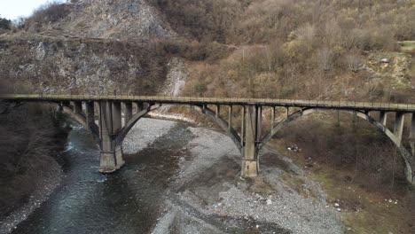 old concrete arch bridge over a mountain river