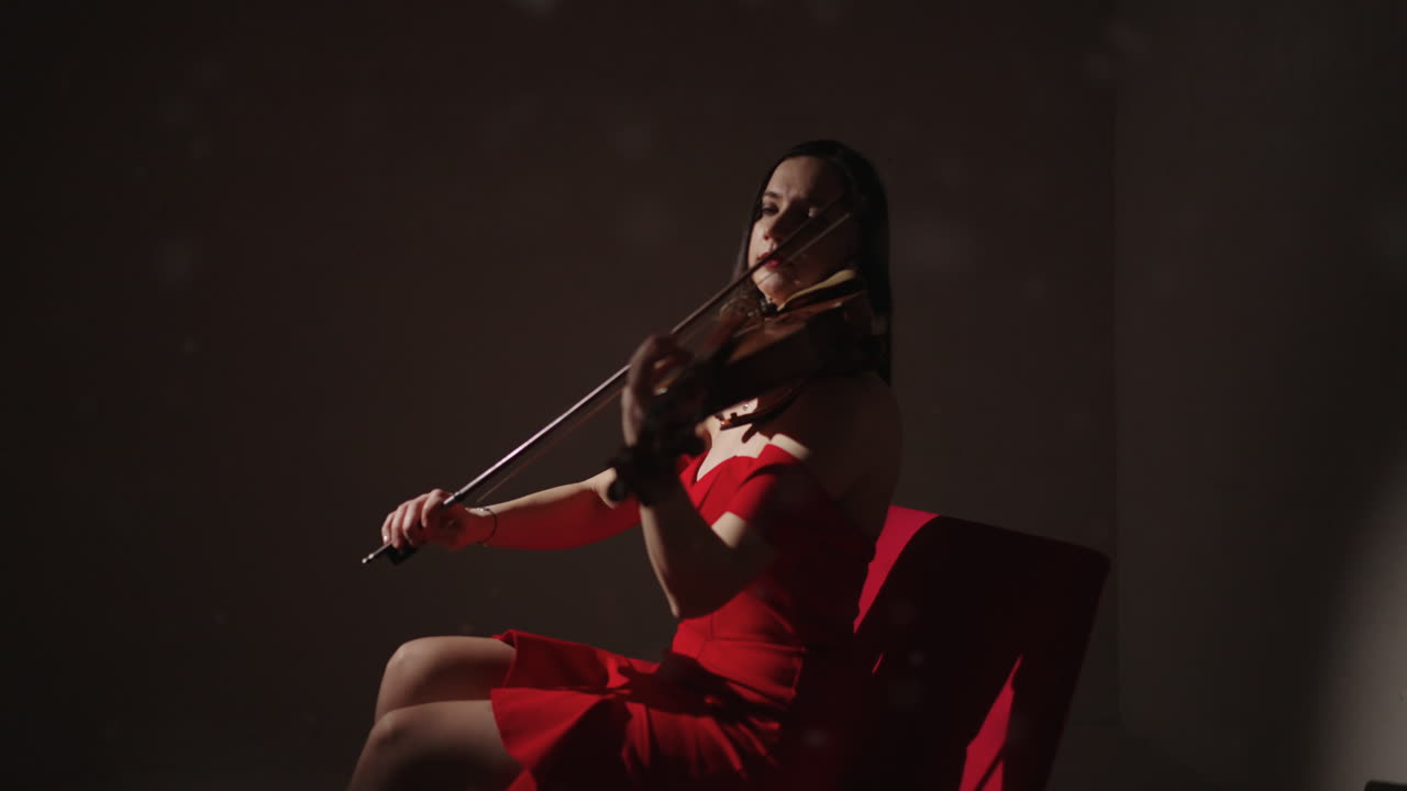 Donna che suona il violino in abito rosso