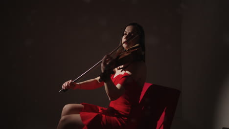 woman playing violin in red dress