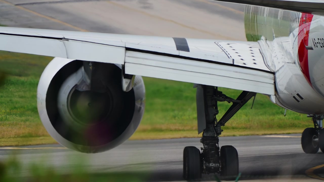 Primo piano del motore a reazione e dell'ala di un aereo a fusoliera larga durante il rullaggio