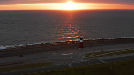 El-Faro-De-Westkapelle-Durante-Una-Puesta-De-Sol-Naranja-Brillante,-Con-Mucho-Viento