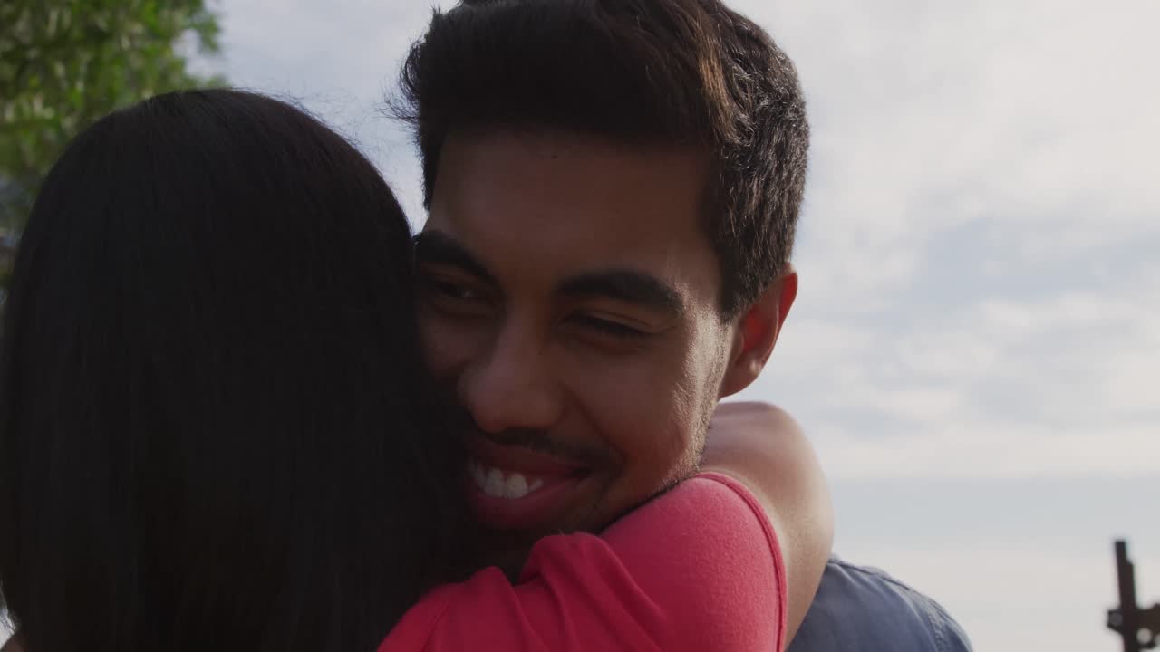 una joven pareja enamorada abrazándose.