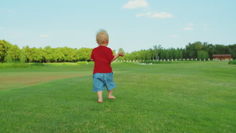 Niño-Pequeño-Corriendo-En-El-Campo.-Niño-Rubio-Divirtiéndose-En-Una-Pradera-Verde