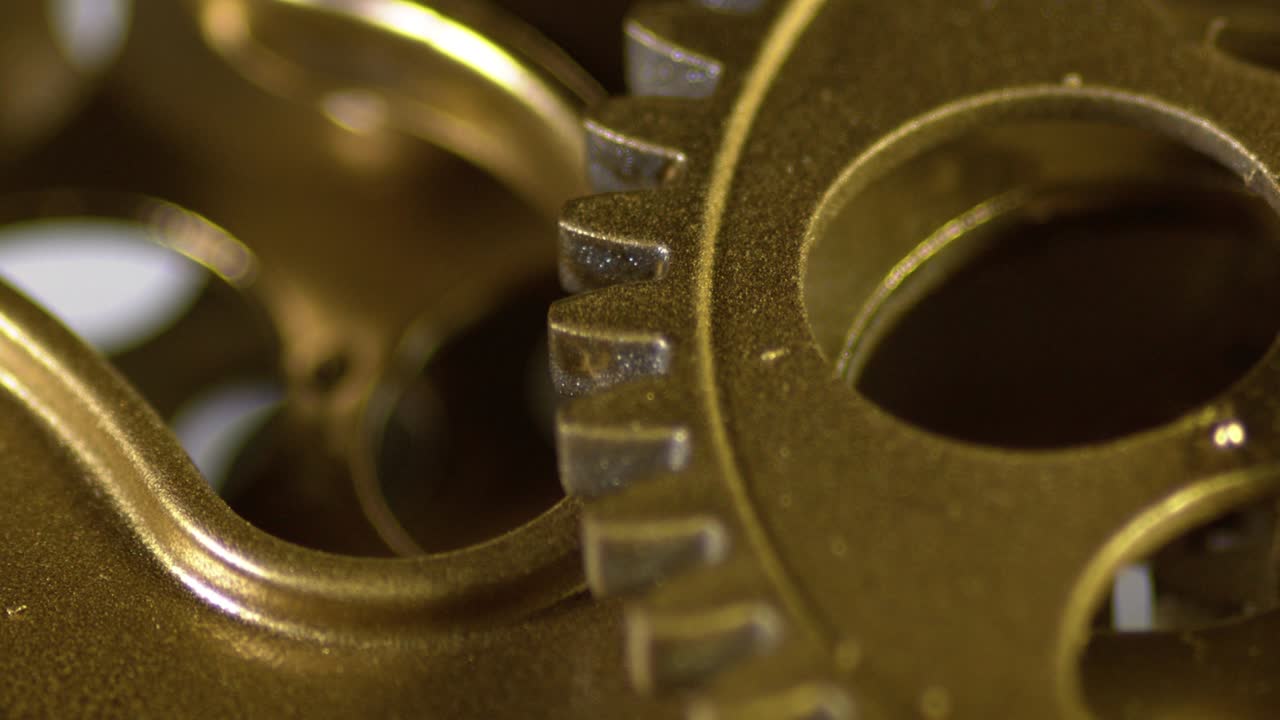 오래된 황금 기어가 작동하는 메커니즘에서 회전합니다.