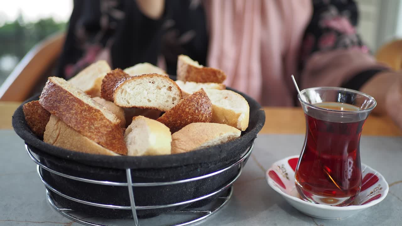 mujer comiendo pan y té turco