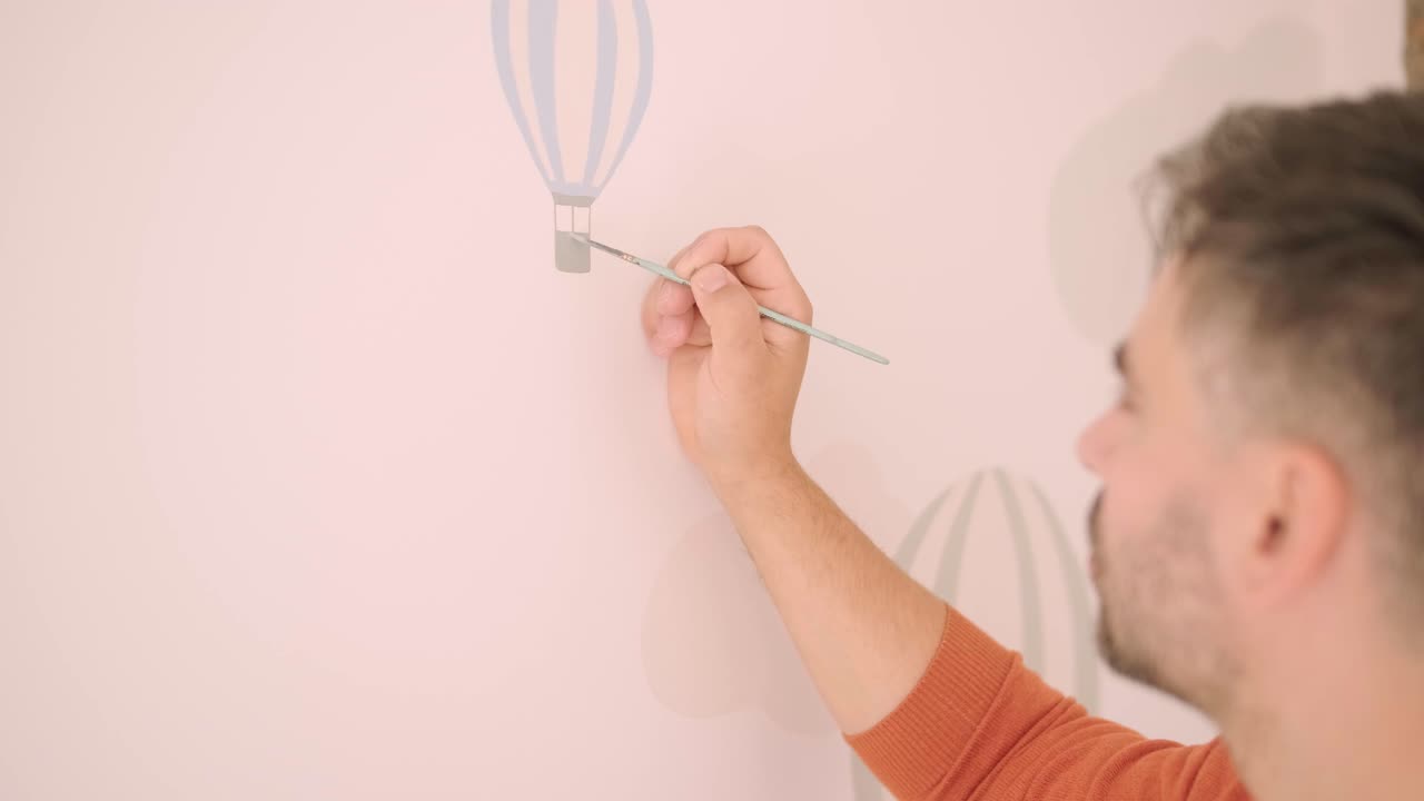 el artista está decorando las paredes con dibujos en la habitación de los niños. pintura de arte de las paredes en la casa nueva. trabajos de reparación.