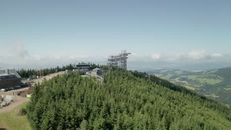 toma aérea en órbita de 45 grados de una atracción de la torre sky walk en dolni morava, república checa y un sitio de construcción cercano del puente colgante más largo del mundo