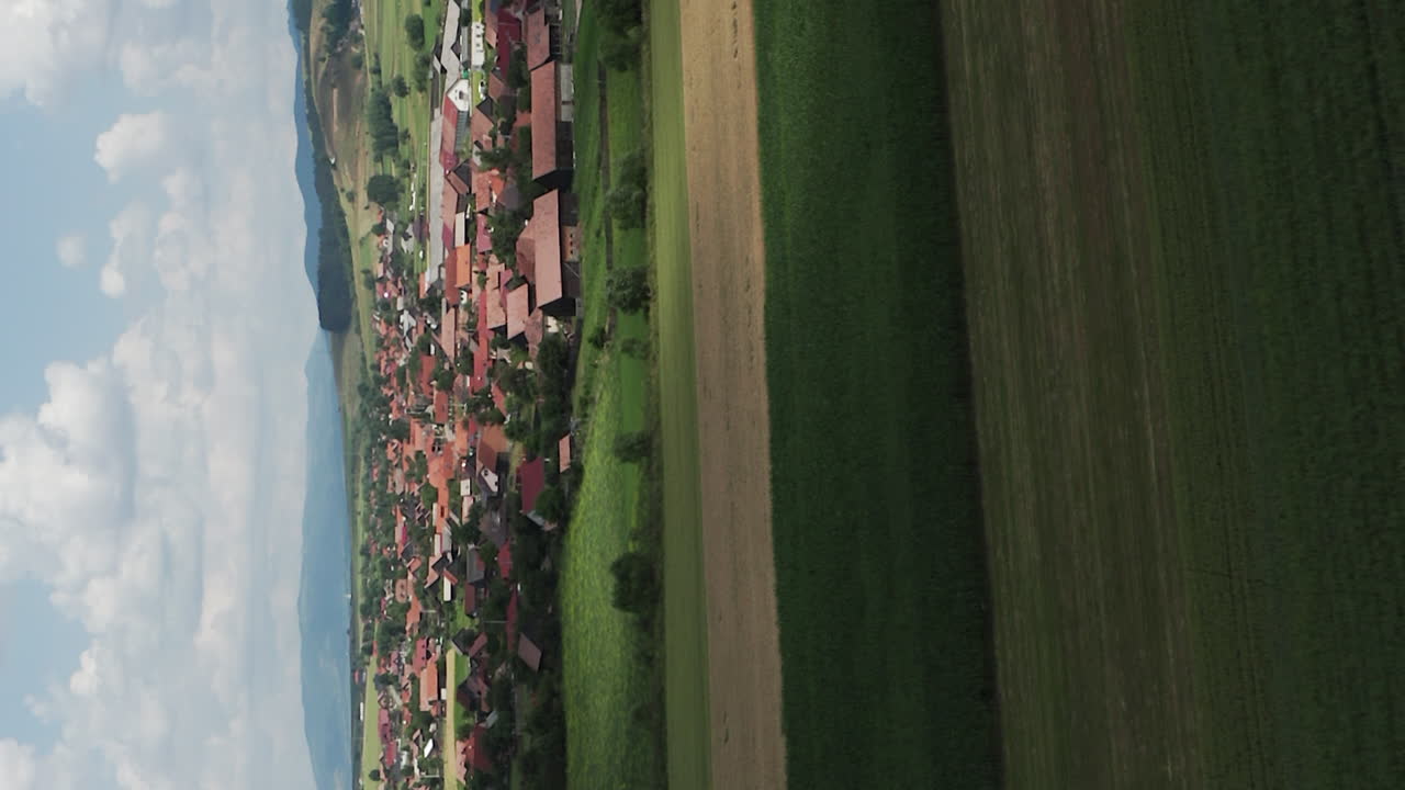 paso elevado vertical sobre casas y tierras de cultivo alrededor de delnita, rumania