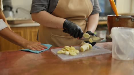mujer en una cocina cortando plátanos