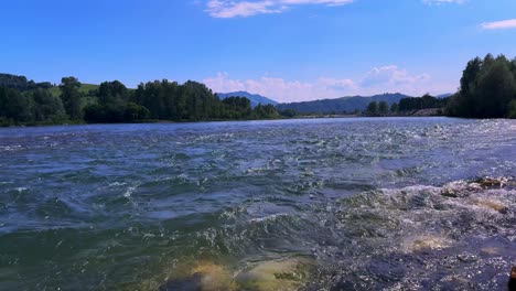 serene river views under bright blue skies with gentle waves and lush greenery in background, capturing nature's tranquility and beauty
