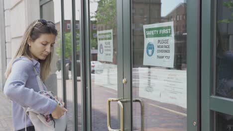 Girl-reads-sign-with-safety-first-written-on-it,-covers-her-face-with-mask