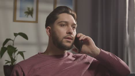 joven complacido en casa recibiendo una llamada telefónica que confirma la oferta de trabajo 4
