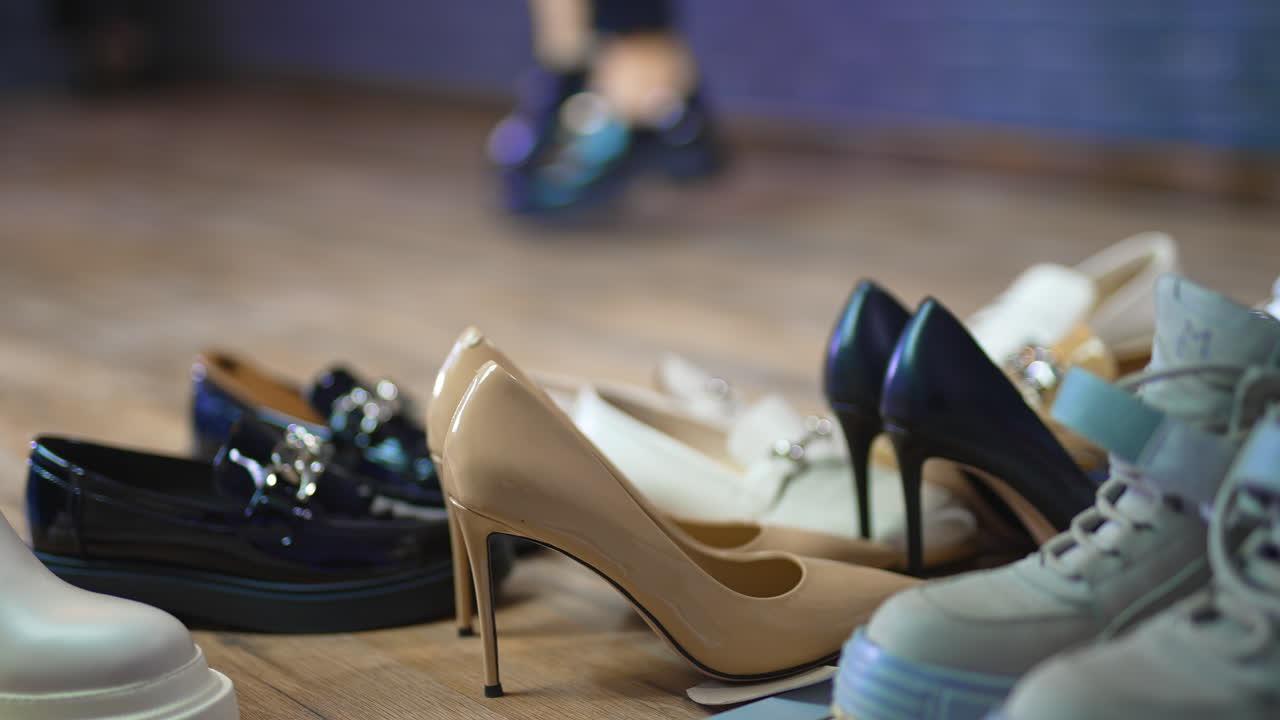 Diversity of footwear for female customers. Close up. Model in black lacquered shoes running at backdrop in blur.