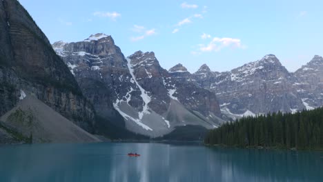 Serene-view-kayak-on-Moraine-Lake-with-snow-capped-mountains-and-pine-trees