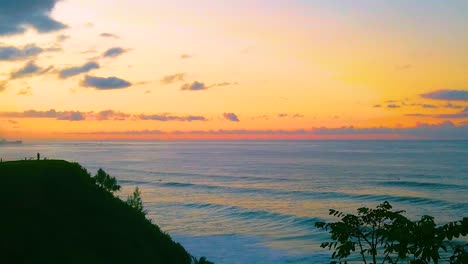 hd hawaii kauai slow motion wide shot pan left to right from a person on a lookout point in frame left to the ocean with a beautiful sky near sunset