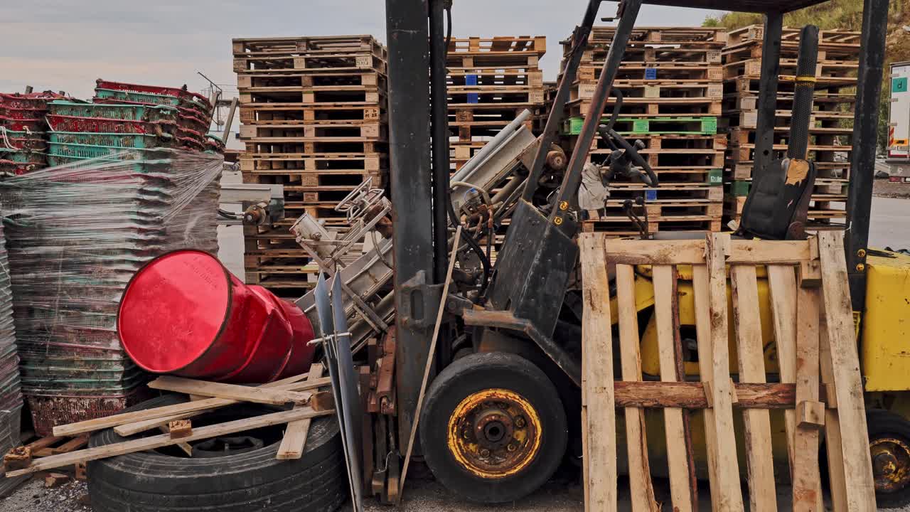Forklift truck in freight handling yard with transport shipping pallets