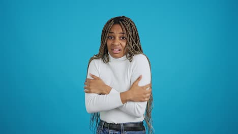 african american woman feeling cold on a blue background