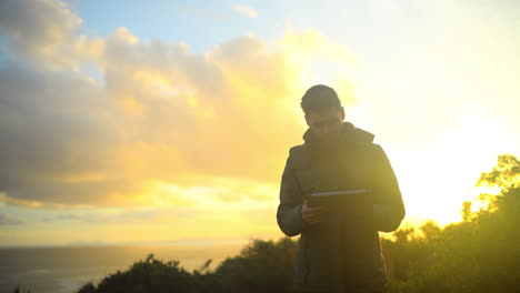 a young man using a tablet outdoors