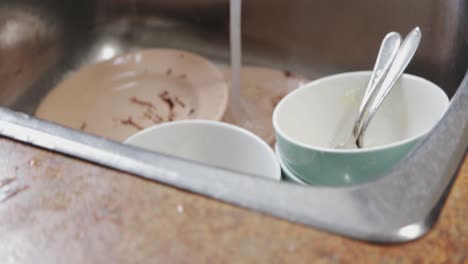 a young person begins washing dishes