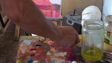 atelier painting artist, red color hand slow motion