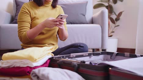mujer reservando un vuelo en línea con su teléfono celular y tarjeta de crédito para viajar en verano