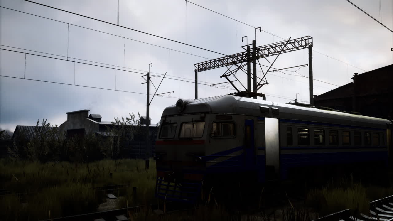 Train parked in an industrial area under a cloudy sky during early evening