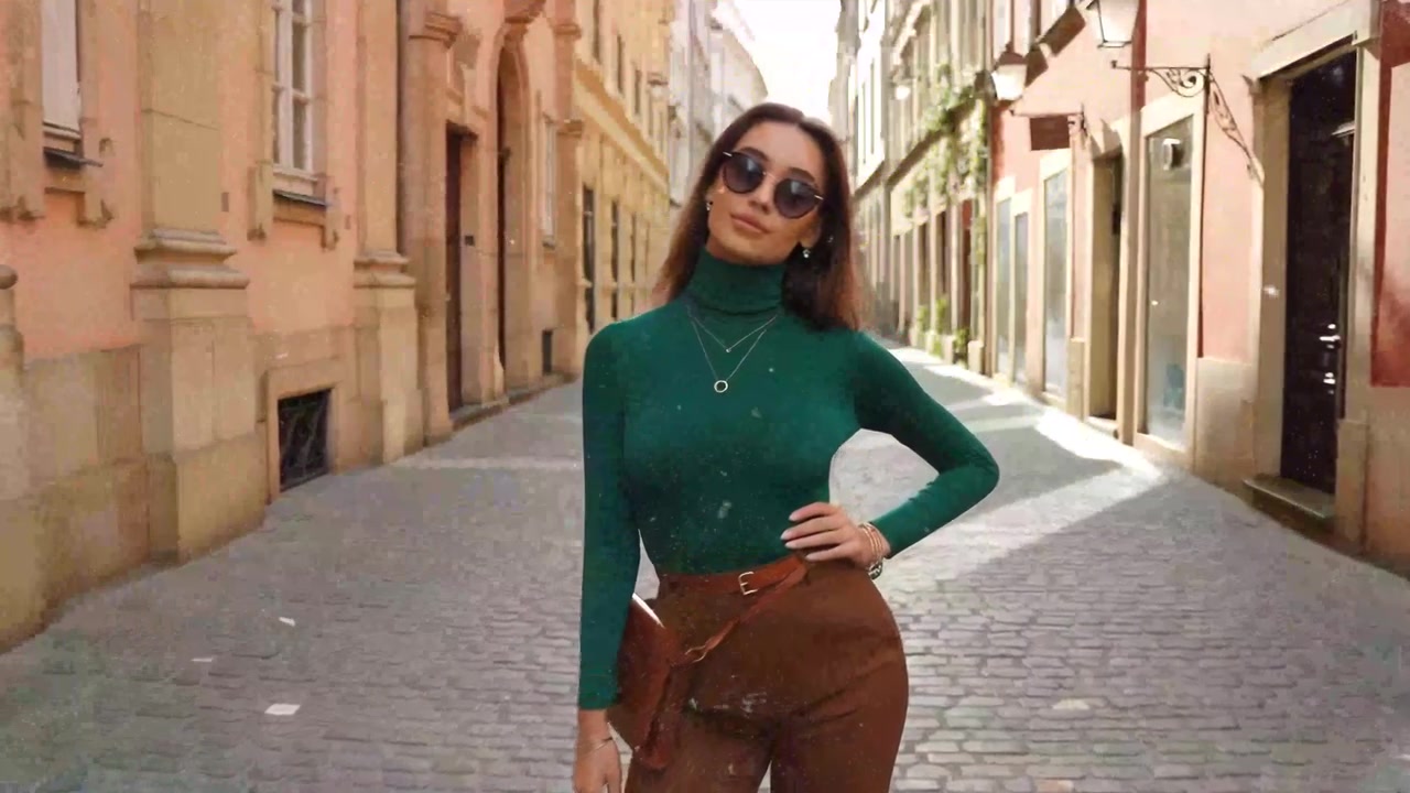 Giovane donna alla moda in posa in una via di città europea