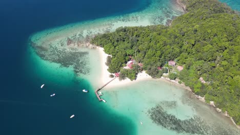 Aerial-Overhead-View-Of-Sapi-Island-On-Clear-Sunny-Day-With-Pier-and-Resort-Buildings-Seen-Below