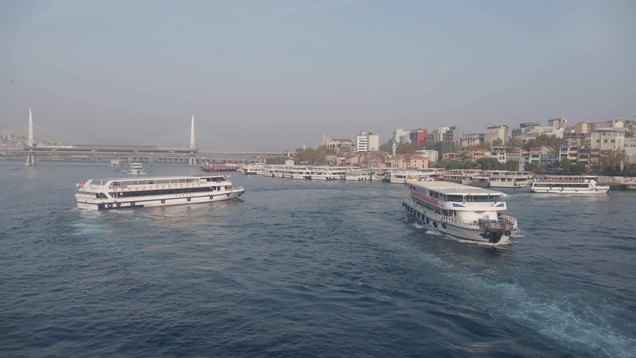 Traghetti che navigano nel Corno d'Oro con lo skyline di Istanbul e un ponte