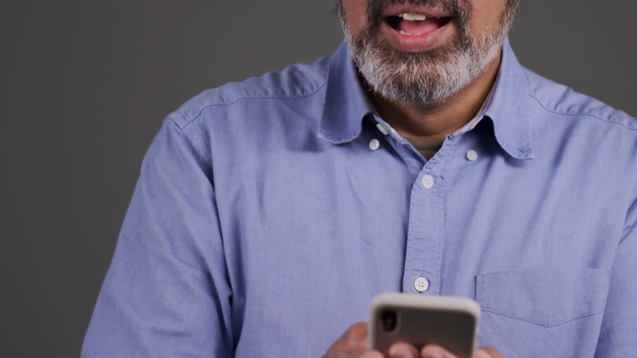 Mann mittleren Alters, der auf seinem Mobiltelefon Nachrichten schreibt