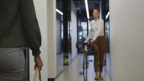 happy diverse business people with bicycle and coffee walking at office