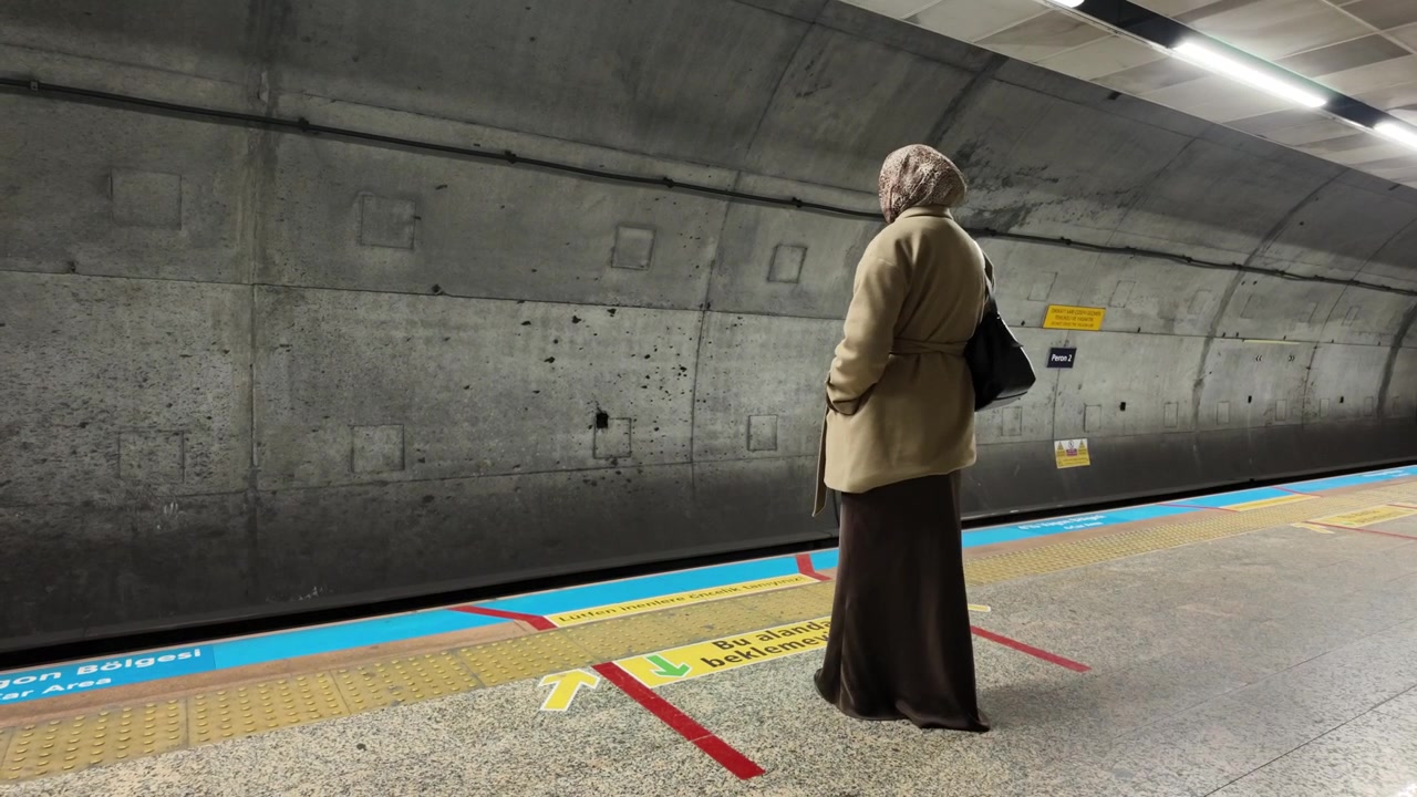Frau mit Hidschab wartet an einer U-Bahn-Station auf den Zug