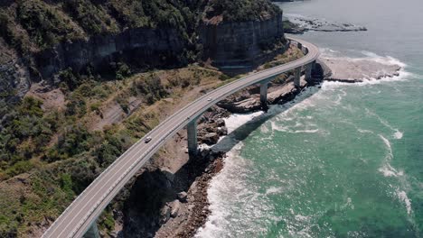 vehículos que conducen en el puente del acantilado del mar en un día soleado en clifton, australia