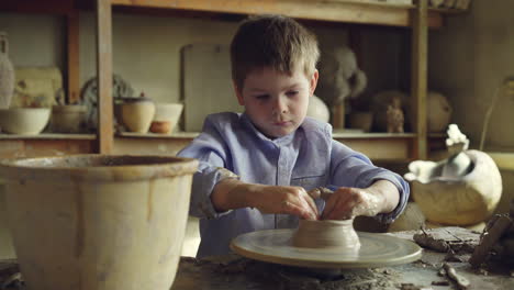 young boy learning pottery