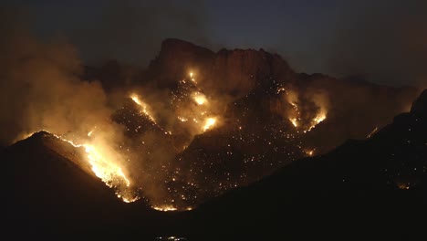 big wildfires at night, burning hills, arson ash and smoke causing air pollution and danger to environment