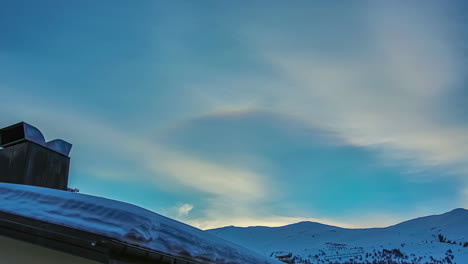 Low-angle-shot-of-snow-covered-over-rooftop-with-a-chimney-on-a-winter-day-in-timelapse