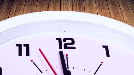 video footage of a wall clock with a ticking arrow at 12, shot with wooden background