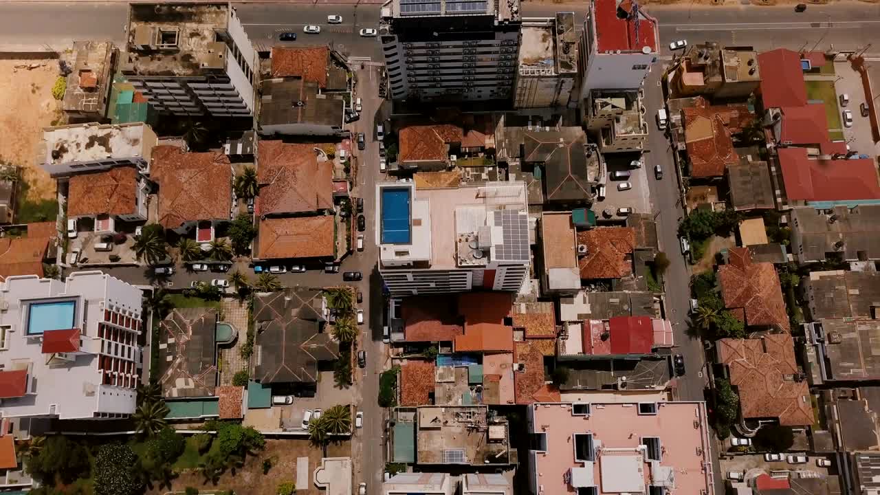 drone volando sobre edificios de colombo, sri lanka hacia la costa. vista aérea de la ciudad turística asiática y el océano