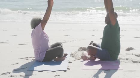 Glückliches-älteres-Afroamerikanisches-Paar,-Das-Yoga-Macht-Und-Am-Strand-Meditiert,-In-Zeitlupe