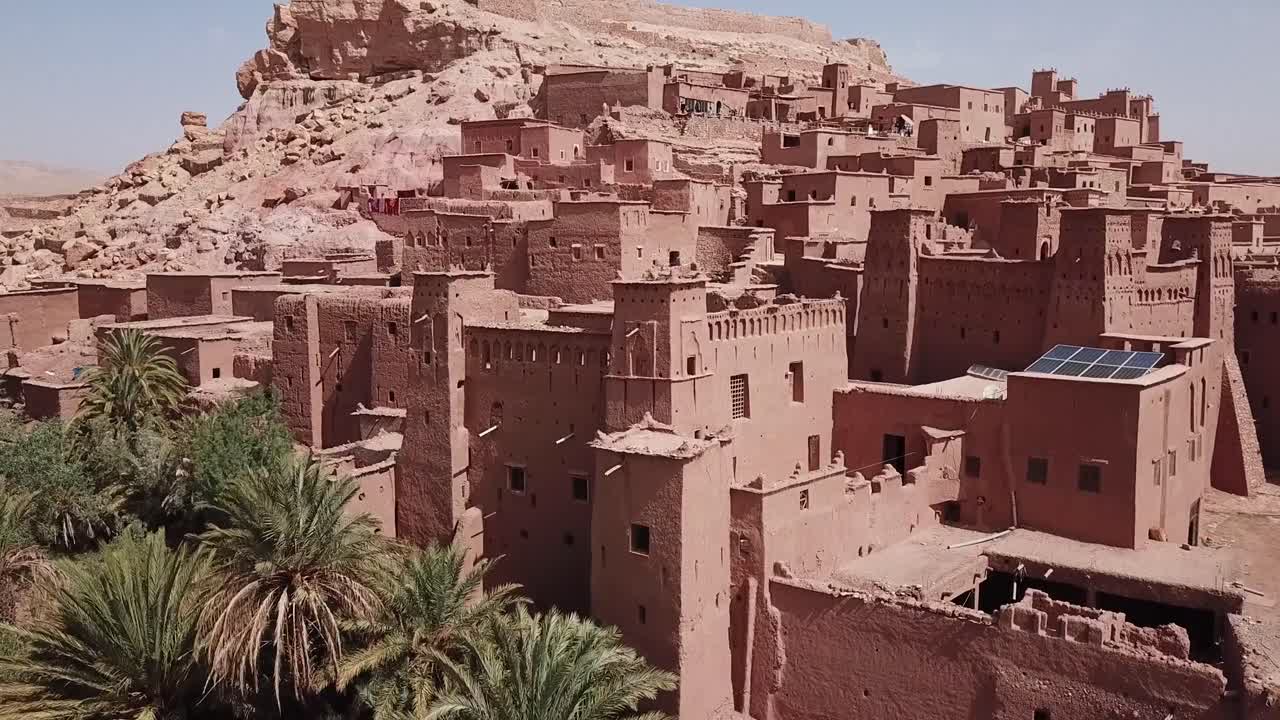 Tiivis näkymä tiheästä marokkolaisesta kasbahista Ouarzazatessa, pinottujen savitiilirakennusten ja kukkulamaiseman kera. Rikkaat tekstuurit ja syvyys tekevät siitä ihanteellisen kulttuurisiin, elokuvallisiin ja matkailuaiheisiin visuaaleihin.